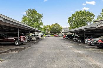 a parking lot with cars parked under roofs